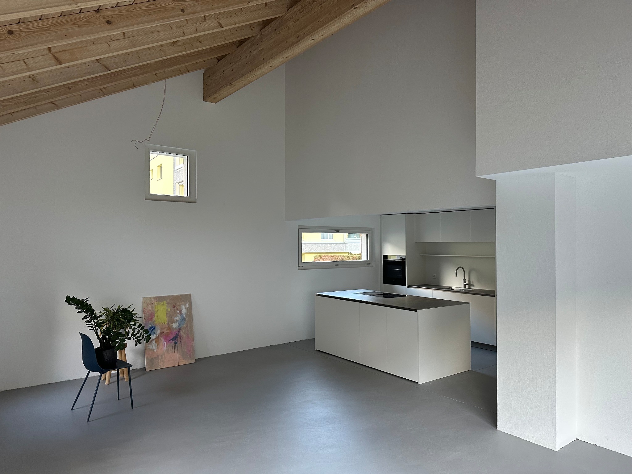 Heller Wohnraum mit Holzdecke und Küche